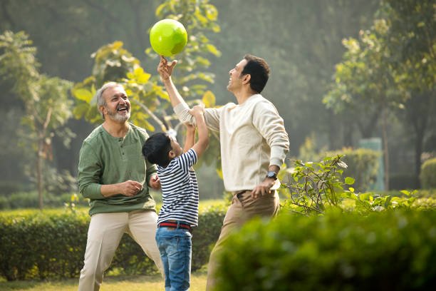 three generation family having fun while playing with ball at park